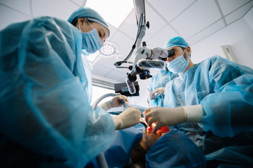 Dentist during a dental intervention with a patient. Dental clinic concept.