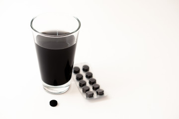 Glas Wasser und Kohletabletten gegen Durchfall