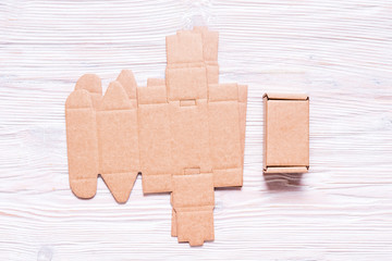 Cardboard box, flat packed, wooden background