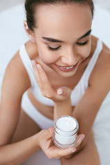 Beauty Skin Care. Beautiful Woman Applying Cream On Face Skin
