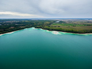 Azure lake "Osadnik Gajowka" top view, abstract fantasy green and brown pattern background