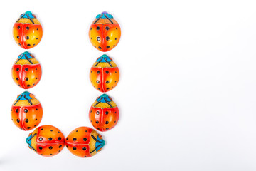beautiful set of multicolored ladybugs forming an letter u in Mexican ceramics, top view, copy space, flat lay, space for text