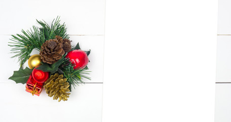 Creative Christmas layout. Christmas centerpiece with fir twigs, pinecone and mistletoe. White wood background whit copy space. Flat lay top view.