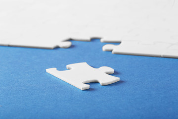 On a blue background, white puzzles and the missing piece