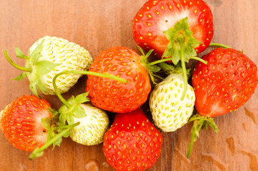 White and red strawberries lie in the sun. Delicious and sweet dessert berry. Vitamins