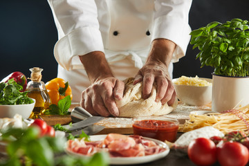 Chef kneading a mound of raw dough