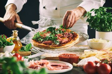 Chef preparing an Italian pizza on a paddle