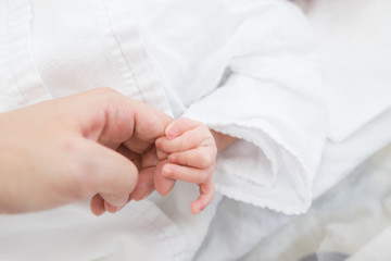 親の指を握る赤ちゃん