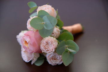 Horizontal shot of glamorous wedding bouquet featuring pink peonies and greenery against mauve background