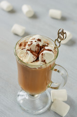 Healthy winter Christmas cocktail - hot cocoa drink or spiced latte with marshmallows and chocolate powder in the glass on the gray concrete background