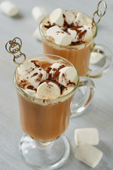 Healthy winter Christmas cocktail - hot cocoa drink or spiced coffee with marshmallows and chocolate powder in the glass on the gray concrete background