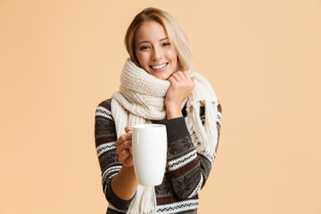 Portrait of a cheerful girl dressed in sweater and scarf