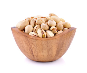 Pistachio nuts in wooden bowl on white background.