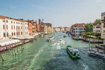 Venice, Italy. Quay of a Grand channel with cargo boats, river trams, boats. Along the canal there are Venetian houses.