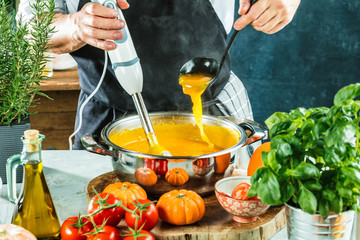 Chef with blender make Pumpkin soup in Kitchen