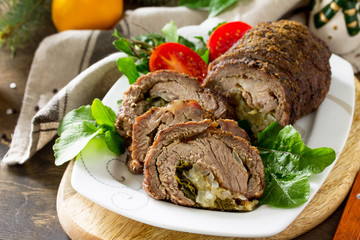 Stuffed Beef Roll with Pear and Cheese on a festive Christmas table.