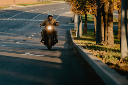 young man riding a motorcycle on the road at sunrise