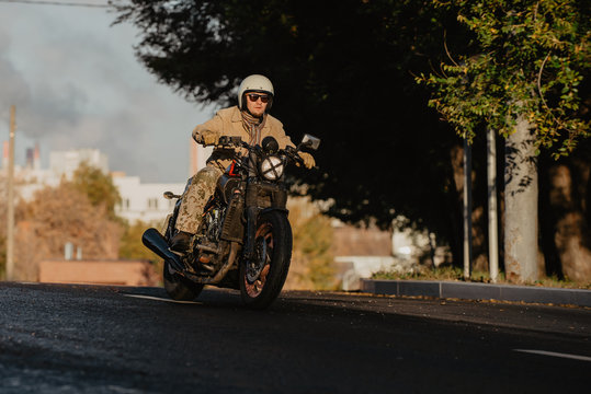 young man riding a motorcycle on the road at sunrise