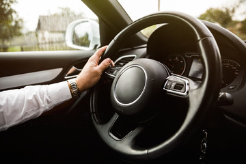  Close-up of a man's hand holding a  car helm. Man driving his c