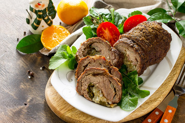 Stuffed Beef Roll with Pear and Cheese on a festive Christmas table. Copy space.