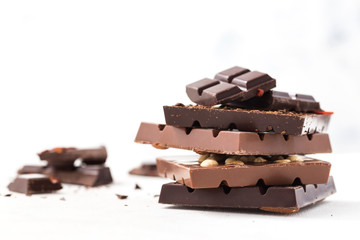 Chocolate bars with nuts, goji berries and coffee beans on a  white background