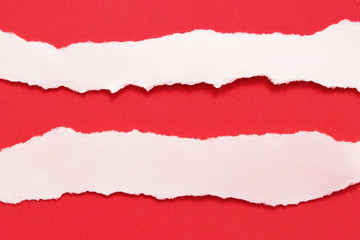 White ripped paper on red paper background. copy space
