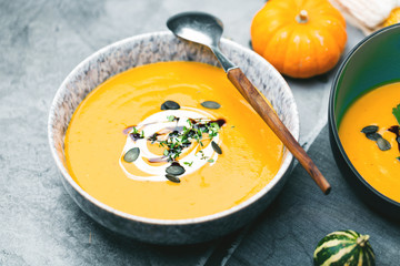 Roasted pumpkin and carrot soup with cream and pumpkin seeds 