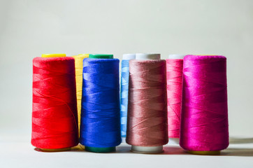 Spools with color threads. Threads of all colors. Isolated. White background.