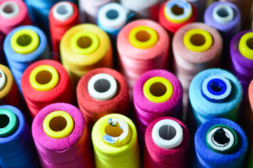Colored thread for sewing. Threads in spools tape measure, needle bar, needle and scissors on a white background.