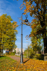 On the alley of the autumn Park beautiful metal lantern