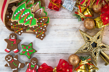 Beautiful Christmas composition and decoration with baked Christmas gingerbread cookie in paper bag on light wooden background, flat lay, top view, copy space (text space)