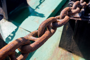 Rusty metal chain (anchor chain) on a ship. Closeup view.