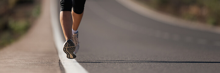 Fitness woman runner athlete running at road, working out cardio on nature landscape