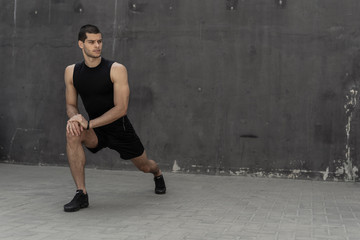 Fototapeta premium Handsome, athletic man warming up stretching before the training