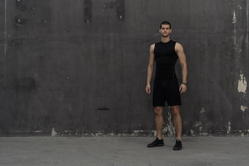 Sport model man posing gray wall background