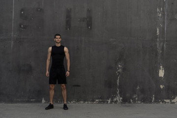 Sport model man posing gray wall background