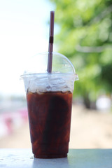 Black coffee with ice on table.