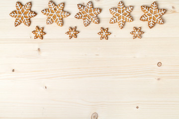 christmas homemade gingerbread cookies on wooden background with empty copy space for text. snowflake and star shapes. holiday, celebration and cooking concept. new year and christmas frame