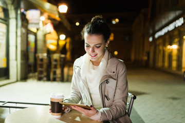 Attractive young woman using tablet in cafe