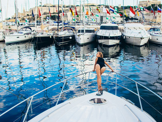 Young beautiful girl staying on front on yacht - obrazy, fototapety, plakaty