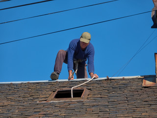 Maintenance of the roof of an old village house with slate tiles.