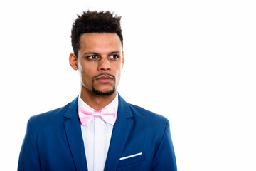 Studio shot of young African businessman thinking while looking 
