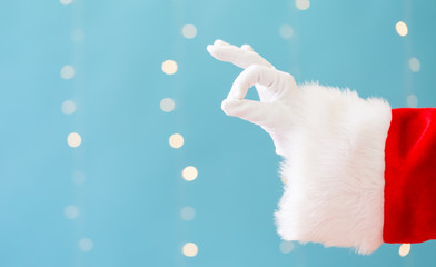 Santa with okay gesture on a shiny light blue background