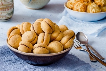 Daci di dama: delicious shortbread pastry filled with chocolate cream on delicate background