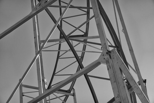 Black and white developed steel struts of a roller coaster at the fairground. - Powered by Adobe