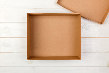 Opened empty cardboard box on wooden background. Top view
