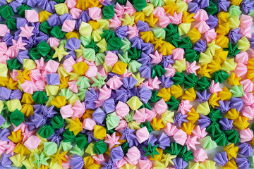 Fototapeta na wymiar Colorful origami stars or flowers folding paper,texture background from crafts