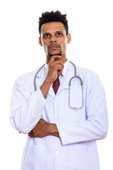 Studio shot of young African man doctor thinking while looking u