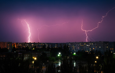 Fototapeta na wymiar Lightning strikes down over the city at night. Beautiful shot. Long Exposure Photography