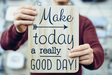 Caucasian man's hands holding motivational message typing on the wooden board. Everyday Inspirational quotes concept. Vintage styled toning. Close up, Selective focus. - Powered by Adobe